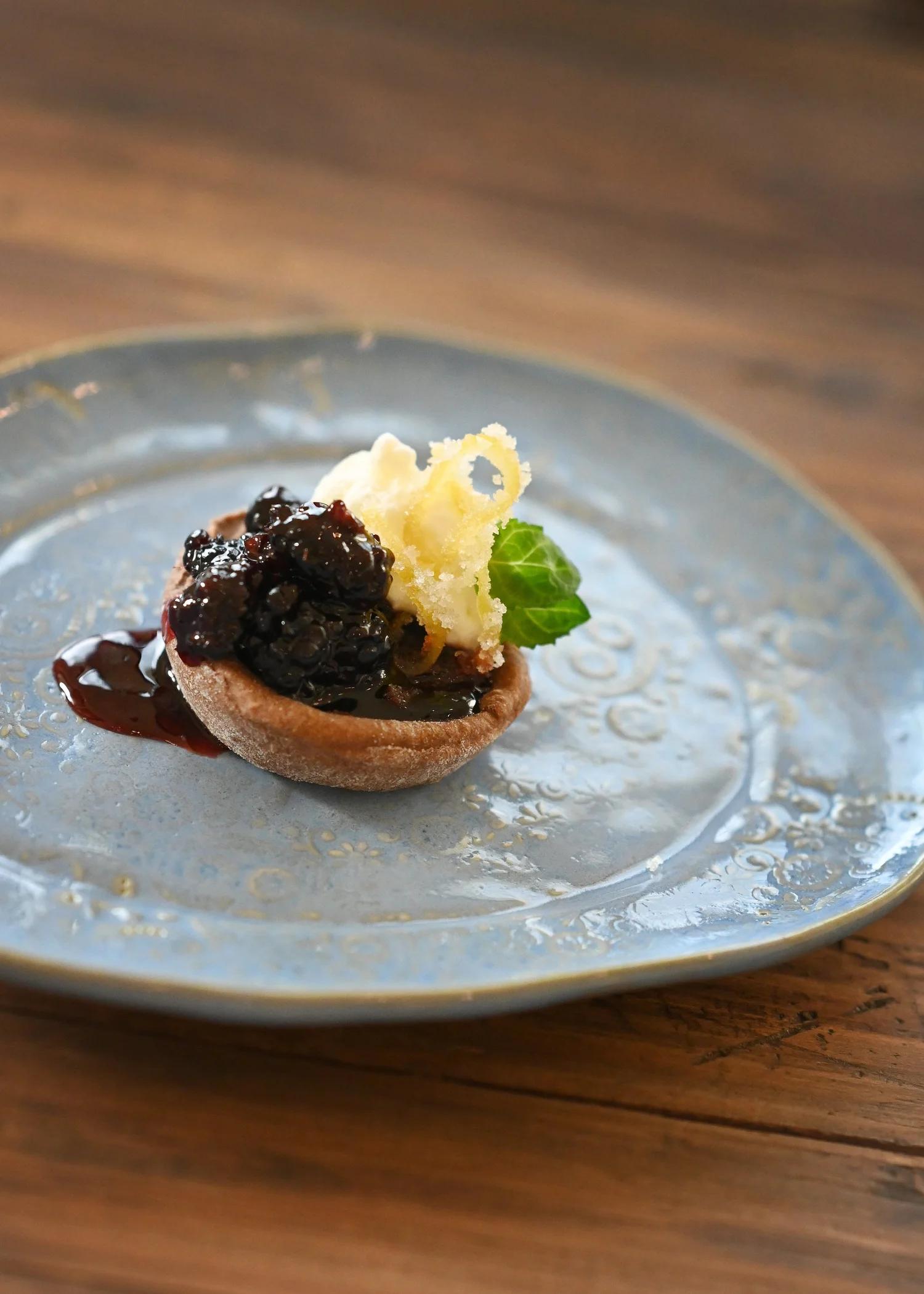 Plated dessert with blueberry jam and candied lemon