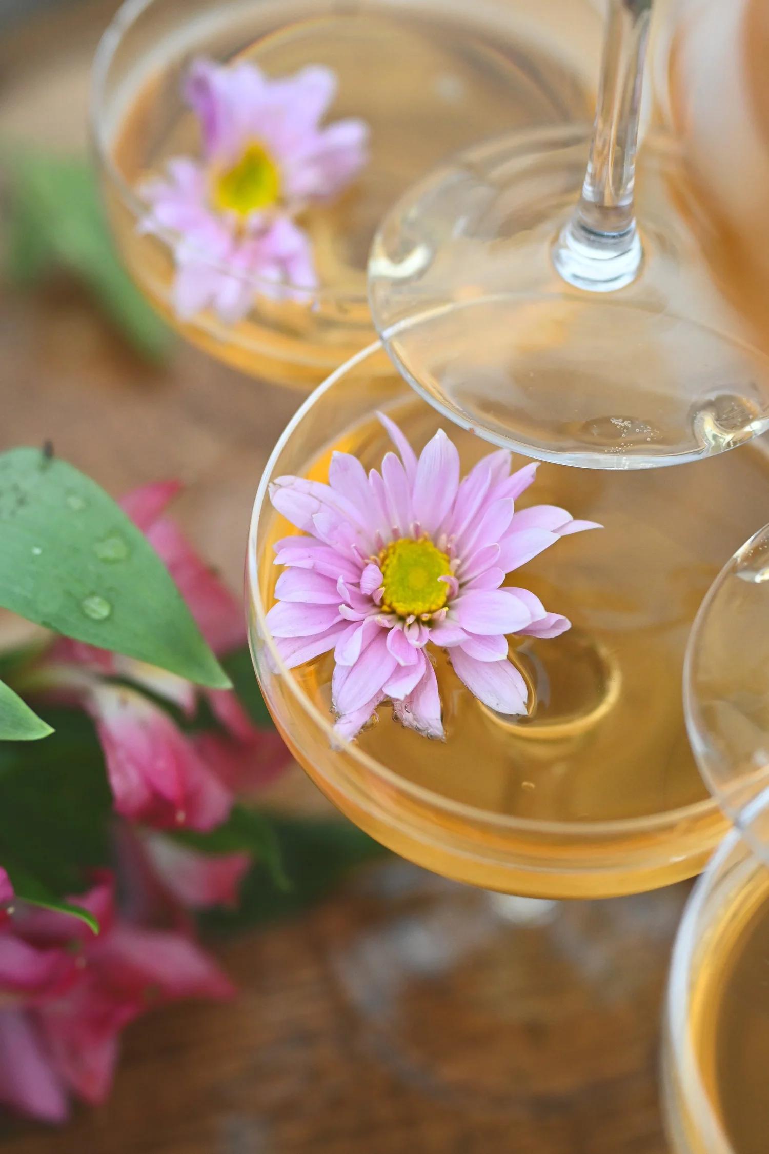 Three flutes of cider with flowers